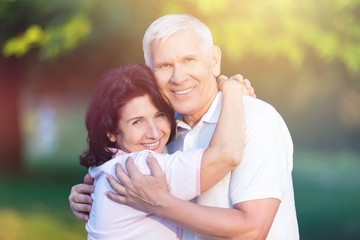 Portrait of happy senior couple smiling in blurred garden background