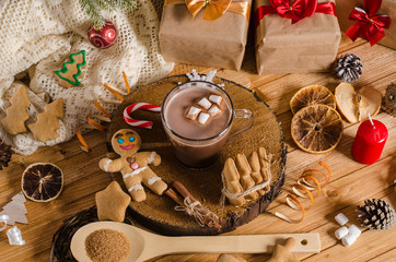 Hot Christmas and New Year's drink of cocoa with marshmallows on a table with gifts, Christmas cookies. Hot chocolate.