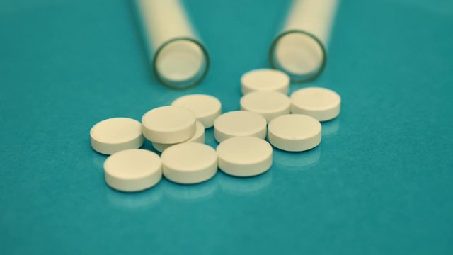 Generic drugs on table top, camera moves slowly accross spilled pills and into the bottle.