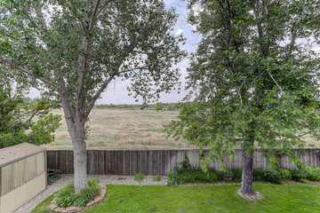 Suburban back yard with open space prairie beyond