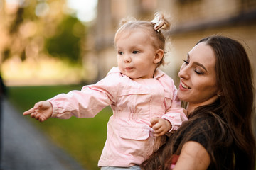 Mother holding her little cute daughter in the arms