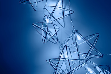 Festive background made of neon stars shaped lights on dark. Party concept. Classic blue color of the year 2020. Christmas time. Perfect new year backdrop. Copy space, flat lay