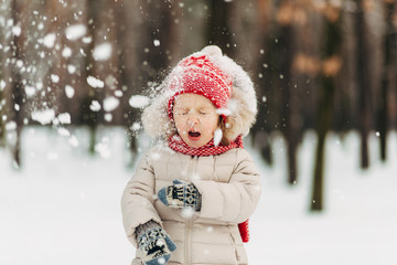 little child girl having fun with snow.wintertime outside in the park