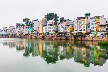 Fototapeta premium Cityscape Scene with Hanoi Riverside Buildings Reflected in water in Hanoi City, Vietnam