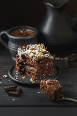 Chocolate cake in black plate on wooden table
