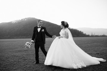 Bride and groom on their wedding day. Young wedding couple enjoying romantic moments outside.