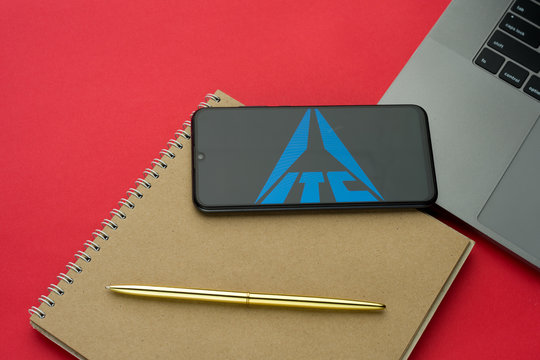 Tula, Russia - 06 december 2019: ITC logo visible on display smartphone on lattop keyboard. Red desk background.