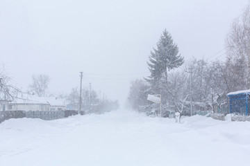 Winter, rural streets are covered with snow. Snow blizzard