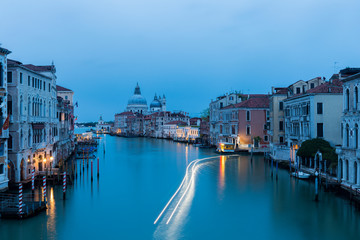 Illuminated boat creates light trails in the Grand Canal of Venice.