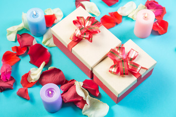 Boxes with gifts for Valentine's day on a blue background in rose petals.