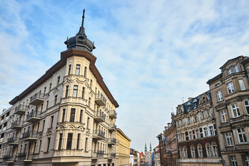 Fototapeta na wymiar Street with historic tenement houses and church towers in Poznan..