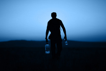 Silhouette of a man against the backdrop of a sunset tinted in classic blue color.