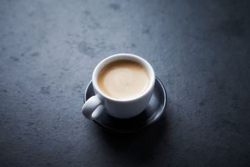 Cup of coffee on dark stone background. Copy space