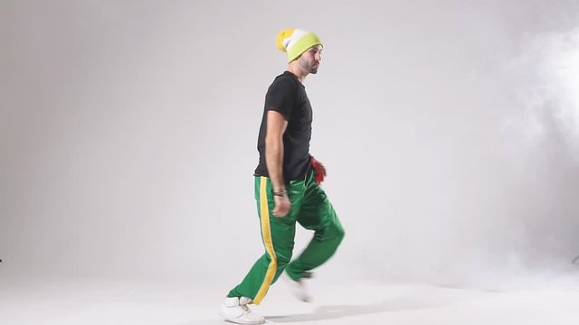 Young active man dressed in sportswear, performing hip hop style dance, training in dance studio