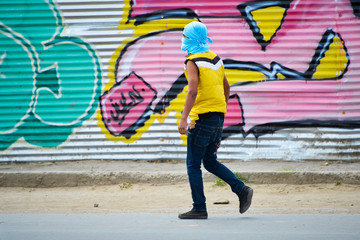 Joven manifestante encapuchado camina en la calle