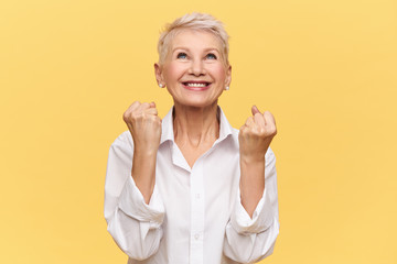 Yes! Fashionable energetic middle aged female rejoicing at her success, reaching goals and...