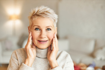 Surprise, amazement and astonishment concept. Beautiful blonde middle aged lady staring at camera...