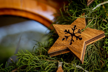 Wooden stars with snowflake pattern on cedar wreath