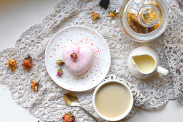 Homemade sweets with romantic decor, dried rose buds and cup of coffee on a white rustic napkin
