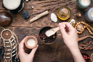 Witch doctor is preparing a magic potion on her table.