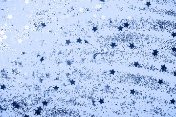 confetti and stars and sparkles on Classic Blue Christmas background. Top view, flat lay. Copyspace for text. Bright and festive holiday background. Color of year 2020.