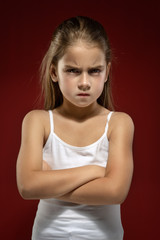 portrait of a little beautiful girl in a white T-shirt on a black background. Emotions