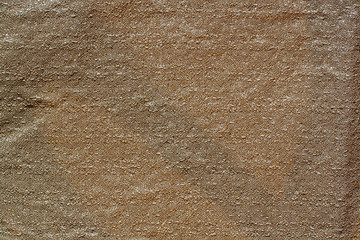 The texture of the fabric. Brown fabric with a crumpled surface. Copy space