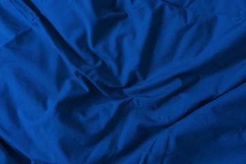 Bed linen of the blue classic blue color of the 2020 year.  Concept of the color of the year with copy space. The texture of the fabric.