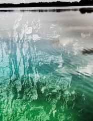 The mixed image of the textured surface of white and grey colors and the natural background of the view of the lake at the warm summer sunset at the City Park. 