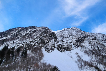 Snowy Mountains peaks in the clouds blue sky Caucasus