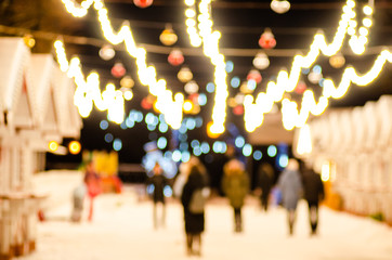 A concept on the theme of lights and illuminations of a city celebrating winter holidays. Out of focus. Lens flares.