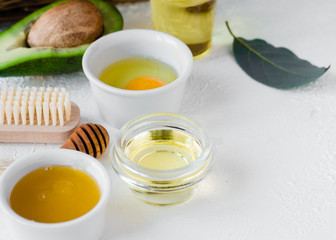 Composition with natural ingredients for facial or hair mask. Avocado with olive oil, egg and honey. Homemade beauty products and zero waste concept