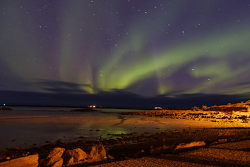 subliem moment of the northern lights, a wave of greenery in the sky with stars in the sky and a reflection in the lake