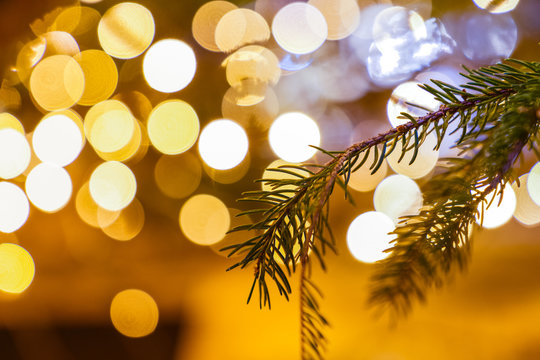 December Christmas decoration on Christmas tree bruches close up, blurred lights in the background / Christmas texture backdrop/ good wishes gift card/ space for text 1/8