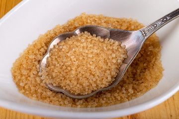 Cane sugar in the home kitchen. Sweetener for kitchen dishes on a wooden table.