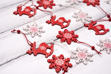 Red and white wooden snowflakes and Santa deers for Christmas tree on white wooden table background