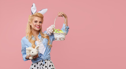 Happy Easter. Young pin up woman with bunny ears hold a string bag full of organic vegetables on...