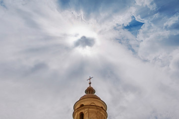 The dome of the old church. Symbolic sign on background with sun in cloudy sky.