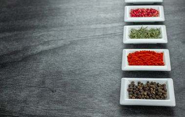 Spices and herbs on wooden table. Pepper, rosemary, tarragon, allspice, turmeric. Colorful spices...