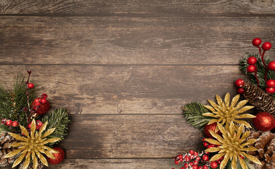 Christmas fir tree with poinsettie and ornaments on wooden background