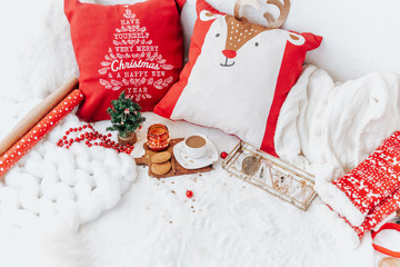 Winter composition with coffee on white bed. Festive cozy concept.