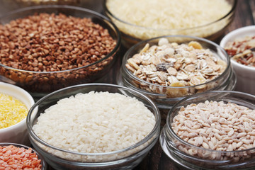 A set of bowls filled with different seeds: buckwheat, rise, corn and oatmeal	