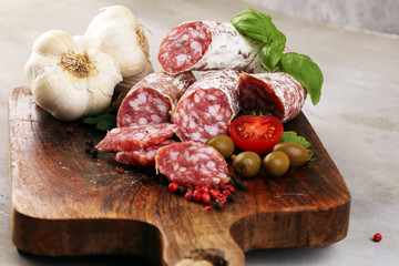 thinly sliced salami on a wooden texture on the background.