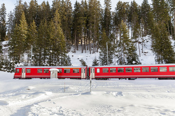 Fototapeta na wymiar Red train running in the snow