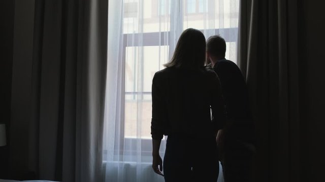Couple enjoying window view from their new apartment