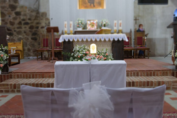 Church sanctuary before a wedding ceremony. Empty chairs for bride and groom.