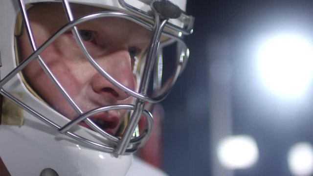 Extreme close up face of concentrated male ice hockey player wearing helmet and waiting for match to begin