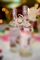 Bottle of cold vodka and wine bottle in bucket with ice and orange juice in jug on table, copy space. Alcohol bottles in ice bucket in restaurant. Wedding party.