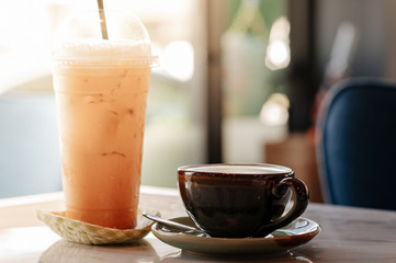 Hot latte coffee with iced Thai tea on the table