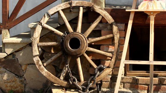 A Large Wooden Wheel And A Wooden Canvass Stand Laying By The Stone Stairs And Fireplace Outside Of A Home In Yuriy Gyumri, Armenia - Wide Pan Shot
